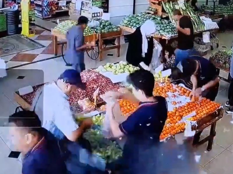 CCTV footage shows a man shopping in a supermarket, with other people milling around.