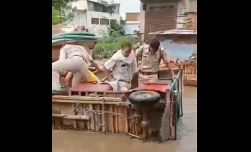 False: A video shows U.P. Police officers rescuing themselves from an overturned vehicle in a flooded street.